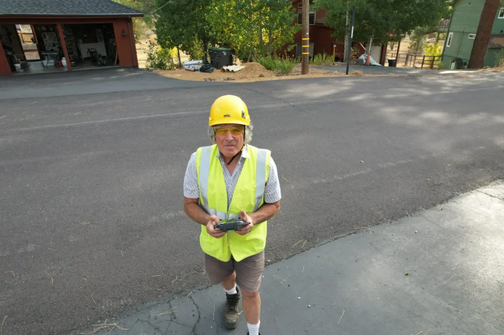 Dave Medara in a hard hat and safety vest flying a drone